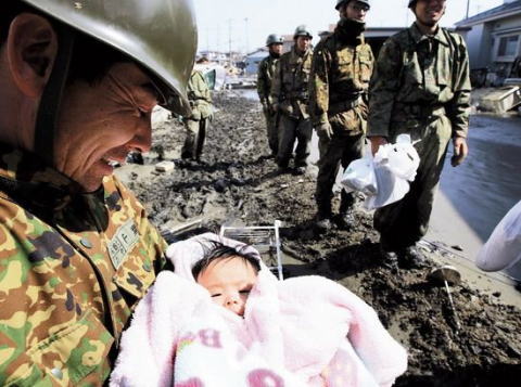 石巻市で自衛隊員に抱かれる4ヶ月の女の赤ちゃん（2011年3月）